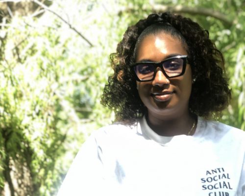 Aaliyah Palmer poses next to a tree at Black Creek Community Farm.