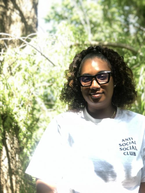 Aaliyah Palmer poses next to a tree at Black Creek Community Farm.